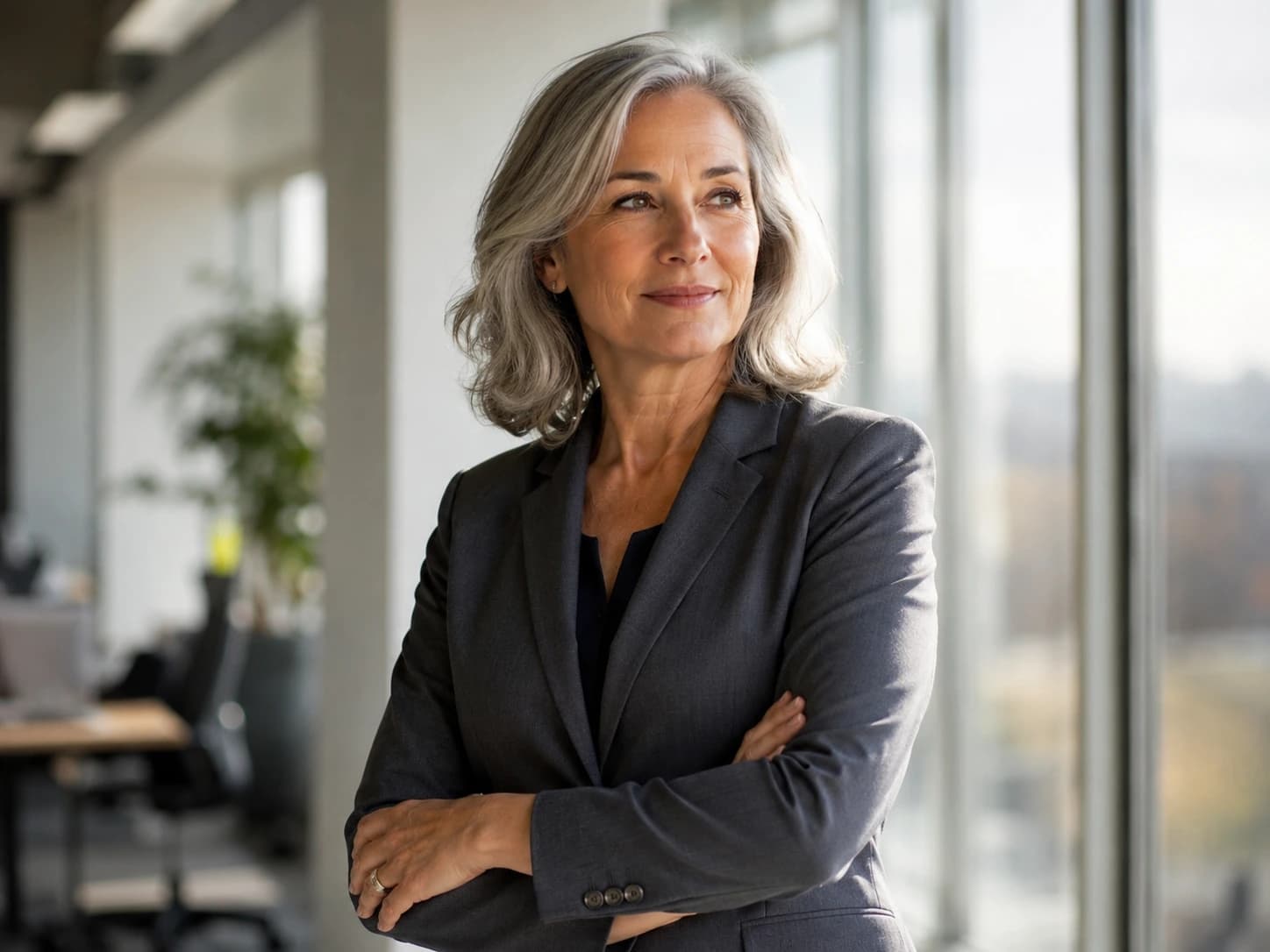 A woman in her fifties in an office, arms folded